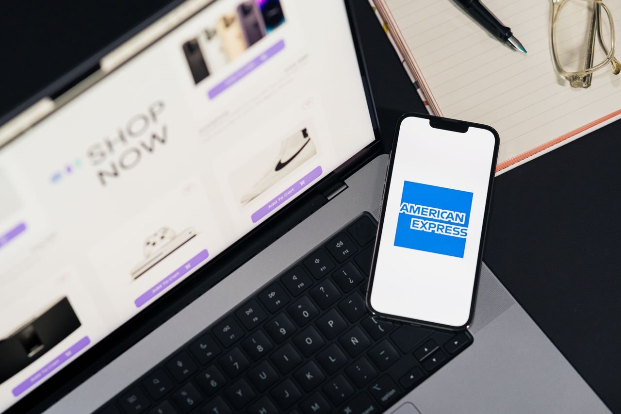 Services Smartphone displaying American Express logo on a laptop for online shopping convenience.